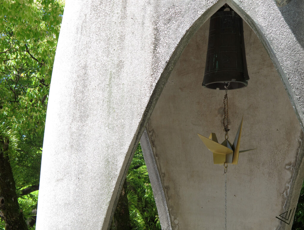 crane sculpture made of bronze hanging from a bell